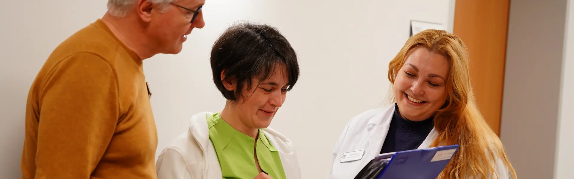 Ärztin, Pflegerin und Therapeutin im Gespräch auf dem Flur